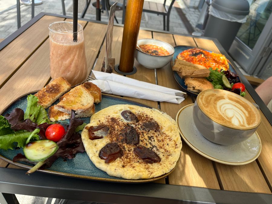 Brunch table with a smoothie, latte and omelette