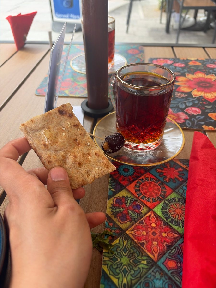 A glass of Persian saffron tea served with flatbread